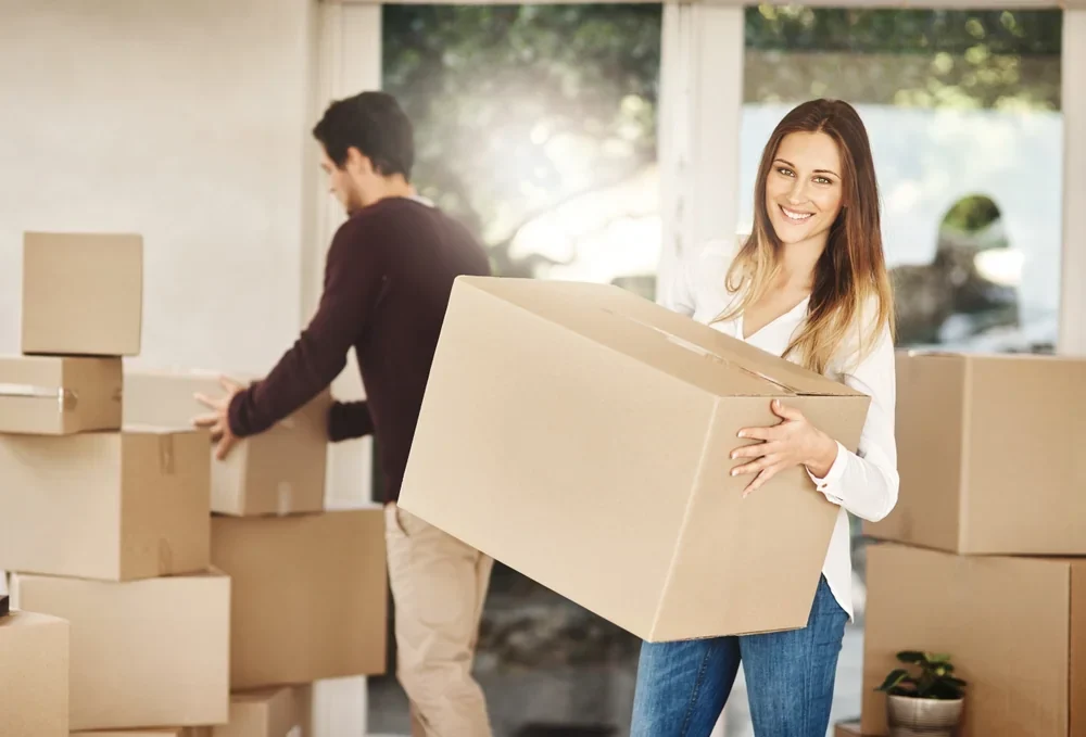 A couple happily moving their belongings to a new home