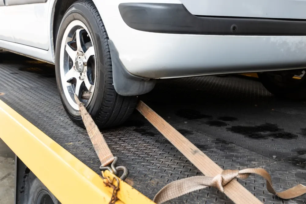 The rear tyre of a car is securely strapped down
