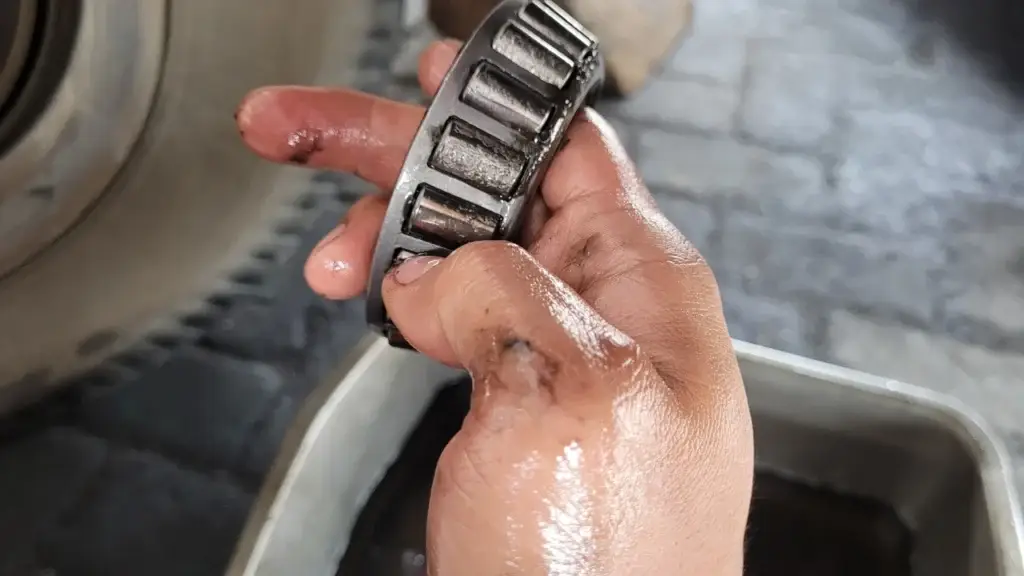 A technician is showing a damaged rear wheel bearing on a truck